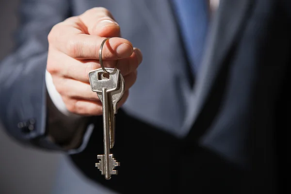 Unrecognizable businessman offering  keys — Stock Photo, Image