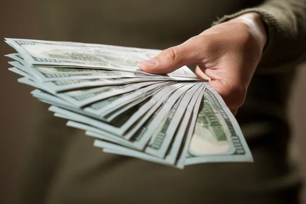 Mano femenina sosteniendo muchos dólares — Foto de Stock