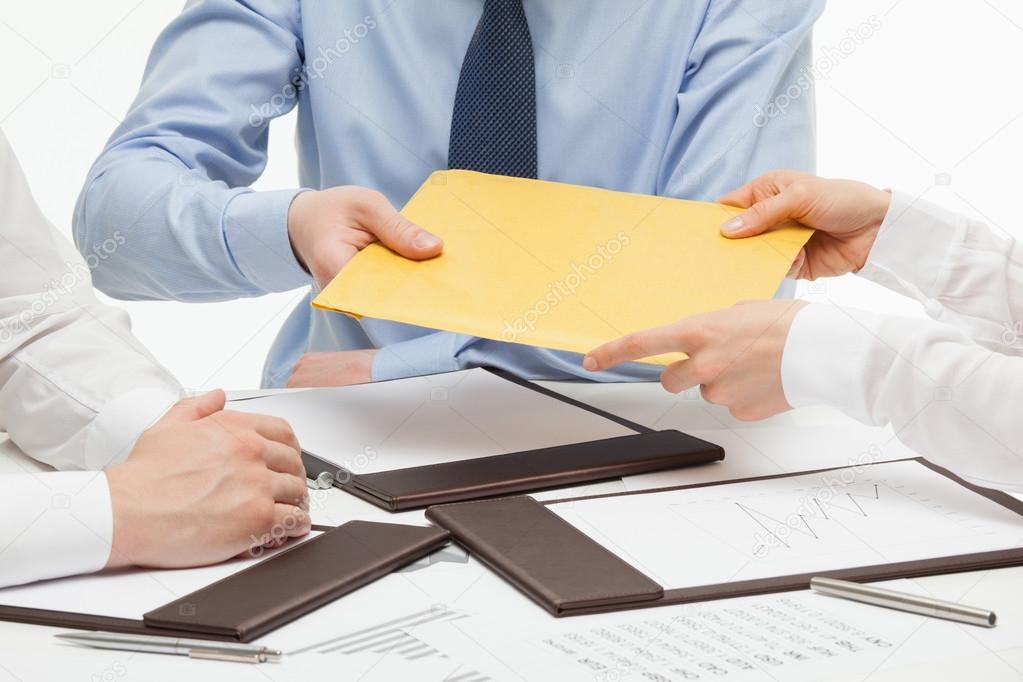 Businesspeople passing an yellow envelope