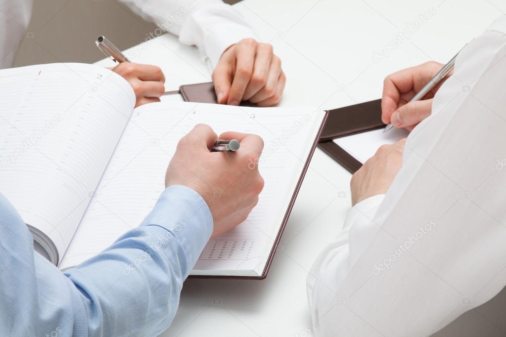 Businessman making notes in  datebook