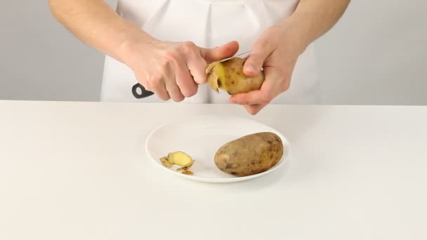 Female cook peeling potatoes — Stock Video