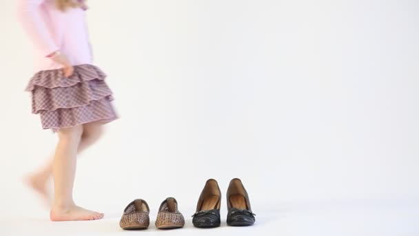 Kleines Mädchen wählt große schwarze Schuhe — Stockvideo