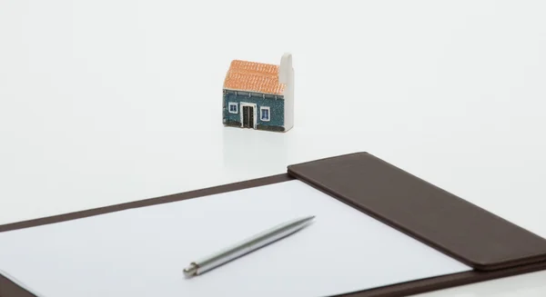 Toy house, clipboard with empty sheet — Stock Photo, Image