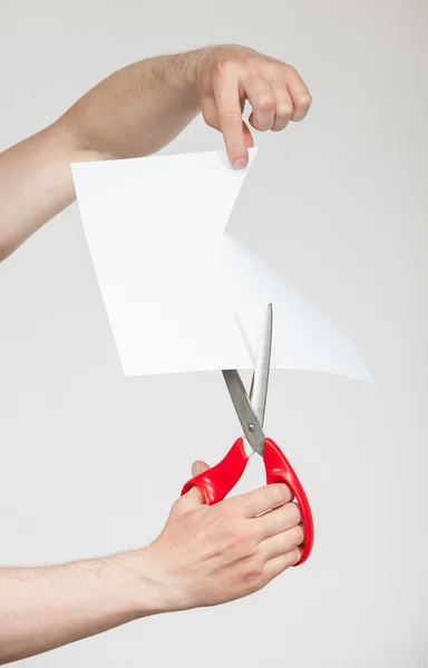 Hands holding scissors and cutting paper — Stock Photo, Image