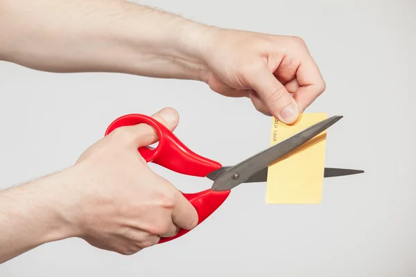 Мужские руки с ножницами и пластиковой картой — стоковое фото