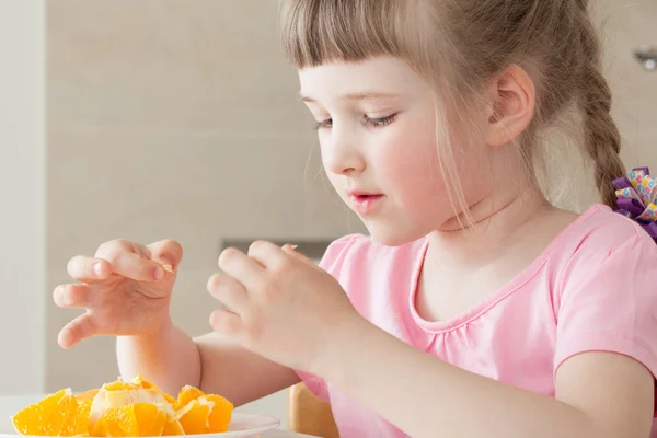Девушка ест апельсин — стоковое фото
