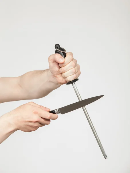 Man sharpening a large knif — Stock Photo, Image