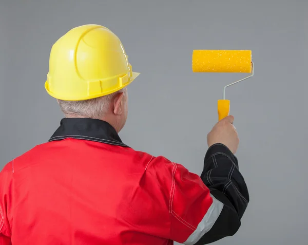 Pintor segurando um rolo amarelo — Fotografia de Stock