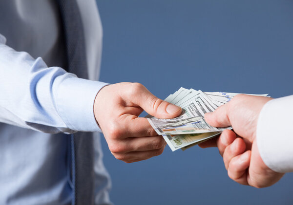 Человеческие руки обмениваются деньгами
