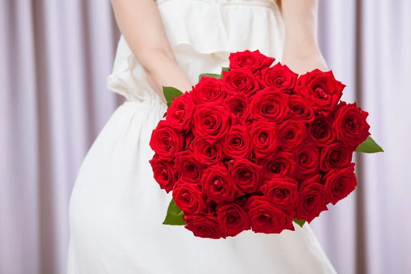 Young woman holding a bouquet of roses — Stock Photo, Image