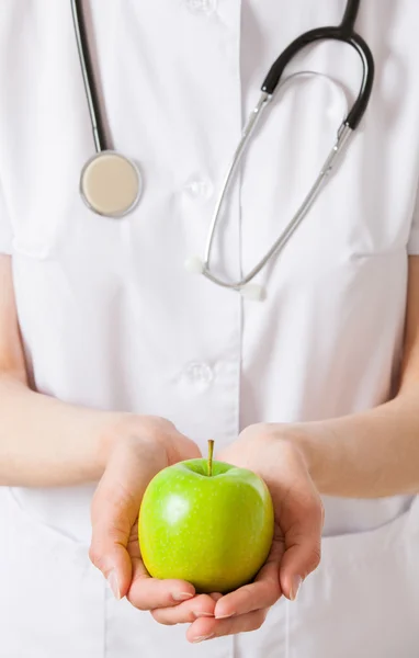 Médico segurando maçãs verdes frescas — Fotografia de Stock