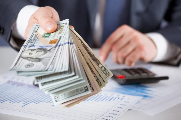 Mãos de homem segurando notas de dólar — Fotografia de Stock