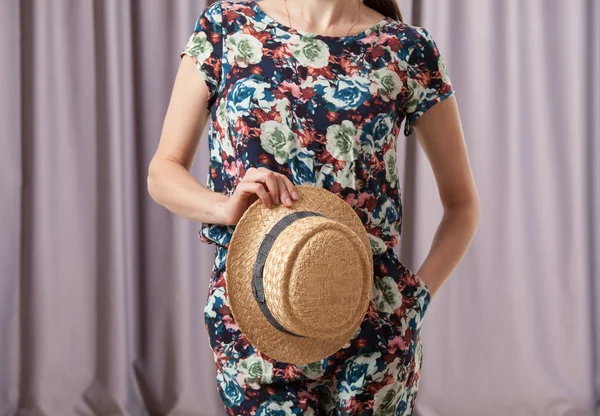 Женщина держит соломенную шляпу — стоковое фото