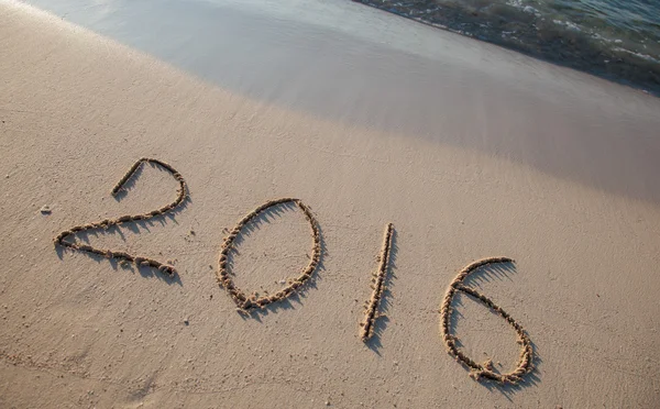 2016 på sand på en solig strand — Stockfoto