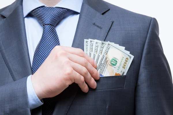 Empresário colocando dinheiro no bolso do peito — Fotografia de Stock