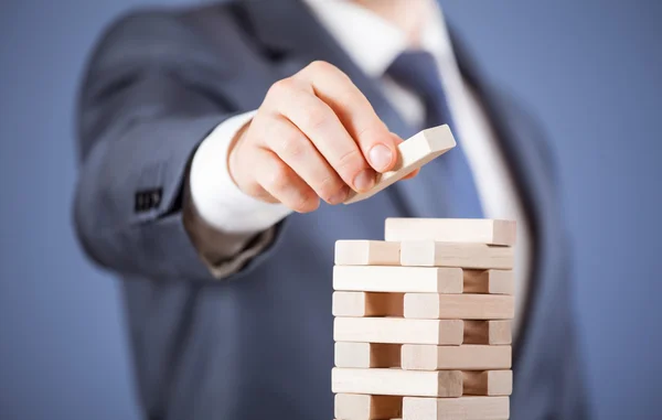 Geschäftsmann formt eine Holzpyramide — Stockfoto