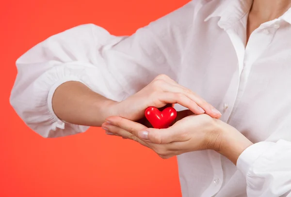 Frauenhände halten ein Keramikherz — Stockfoto