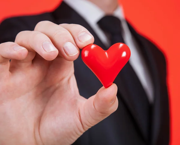 Hombre sosteniendo un corazón rojo en la palma — Foto de Stock