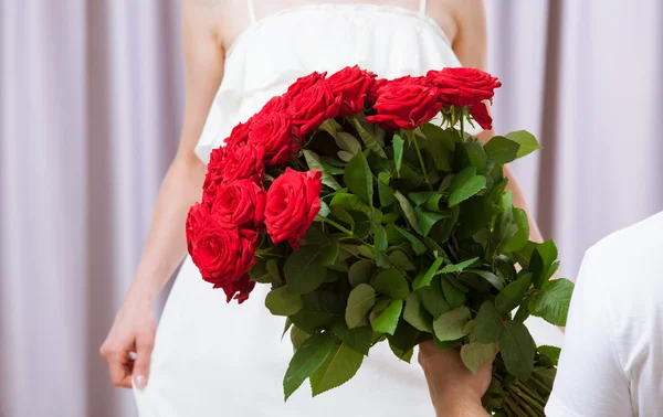 Uomo che dona rose alla giovane donna — Foto Stock