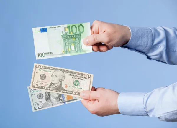 Zakenman vergelijken dollars en euro — Stockfoto