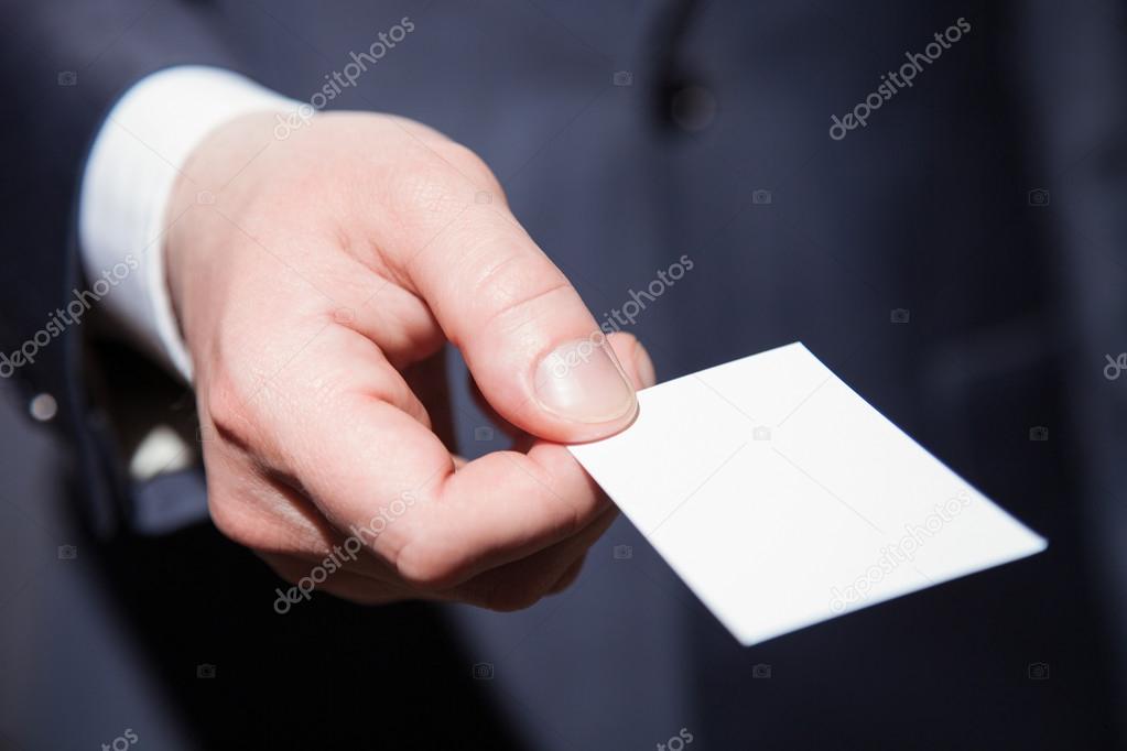 Man's hand reaching out a business card 