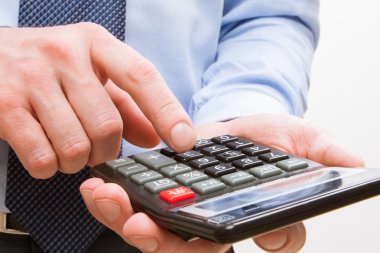 Bir hesap makinesi ile boş ekran tutan işadamı