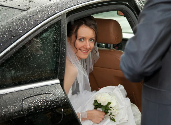 Noiva encantadora olhando para fora de um carro — Fotografia de Stock