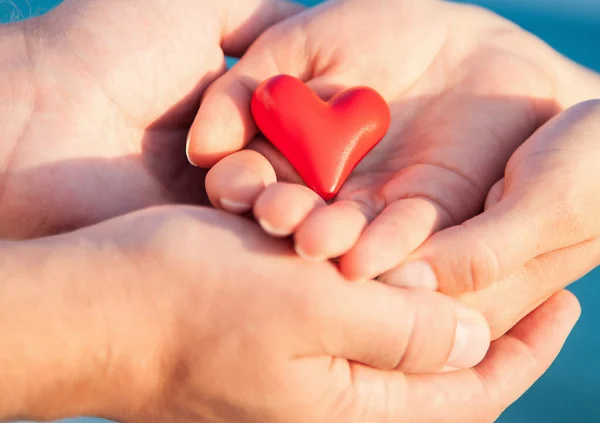 Manos de hombre y mujer sosteniendo el corazón — Foto de Stock