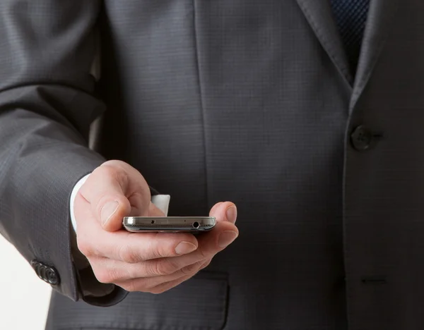 Hombre de negocios irreconocible sosteniendo un teléfono celular — Foto de Stock