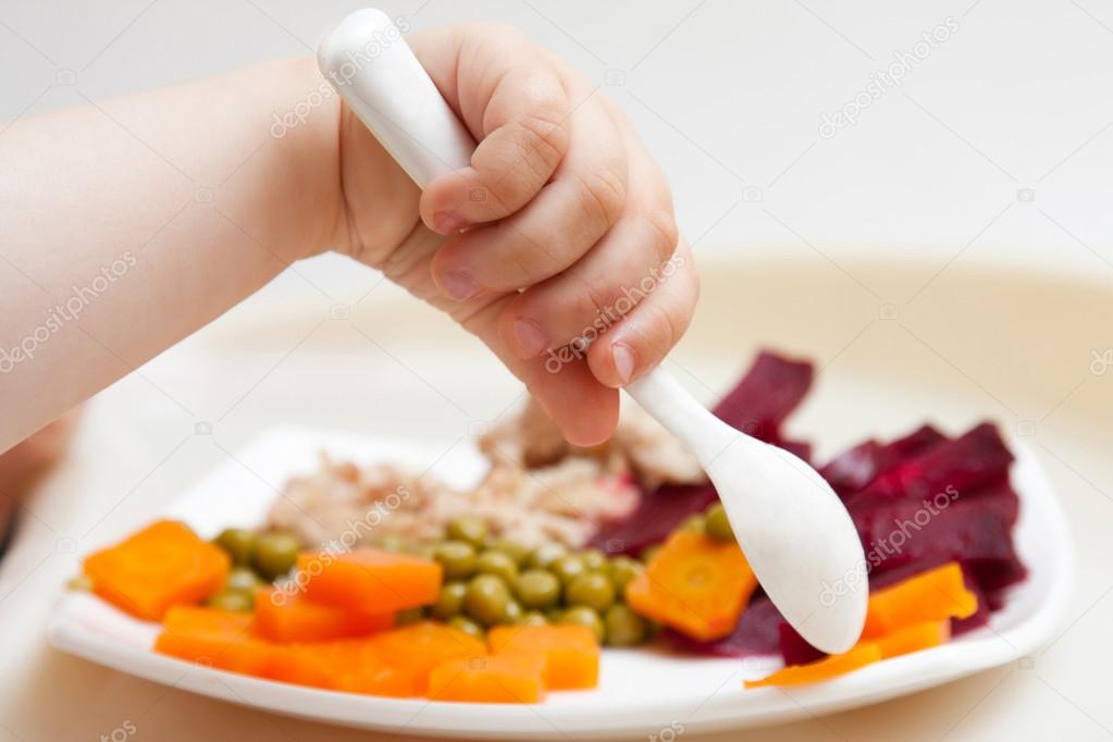 Baby's hand with a spoon