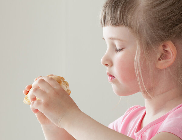 Pretty little girl eating a doughnut 