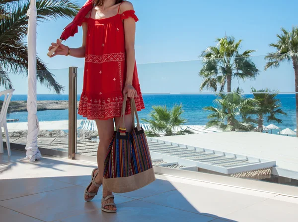 Woman in a red sundress holding — Stock Photo, Image