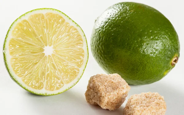 Rijp limes en stukken van suiker — Stockfoto