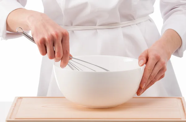 Cook whips something in a white bowl — Stock Photo, Image