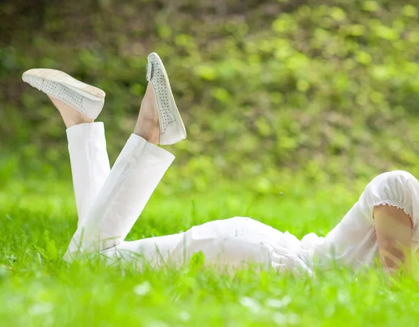 年轻女子躺在绿草上 — 图库照片