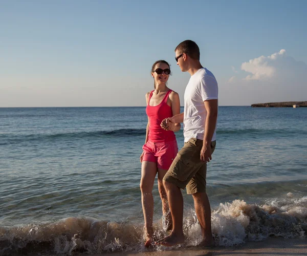 Young couple walking along the seashore — Stock Photo, Image