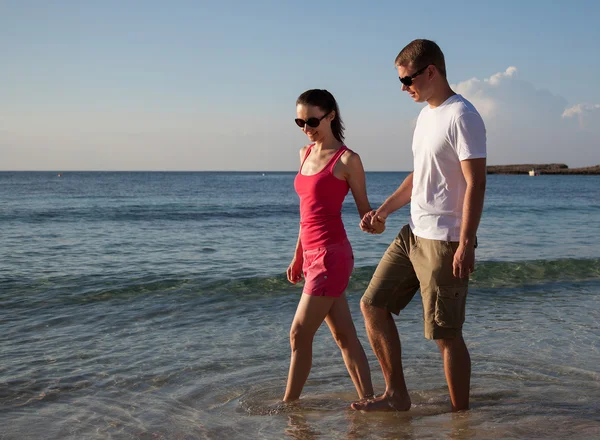 Jong koppel wandelen langs de kust — Stockfoto