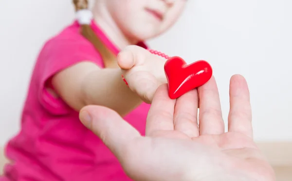 Ragazza dando un cuore rosso a suo padre — Foto Stock