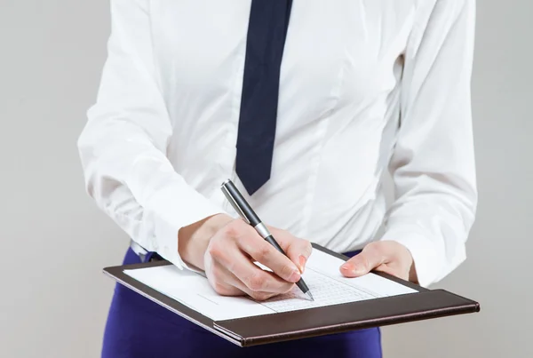 Onherkenbaar jonge zakenvrouw holding documenten en een pen — Stockfoto