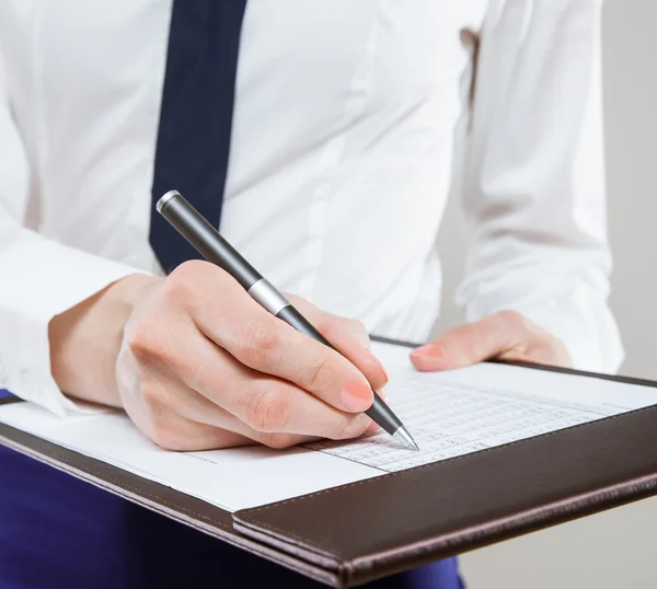 Unrecognizable young businesswoman  holding documents and a pen — Stock Photo, Image