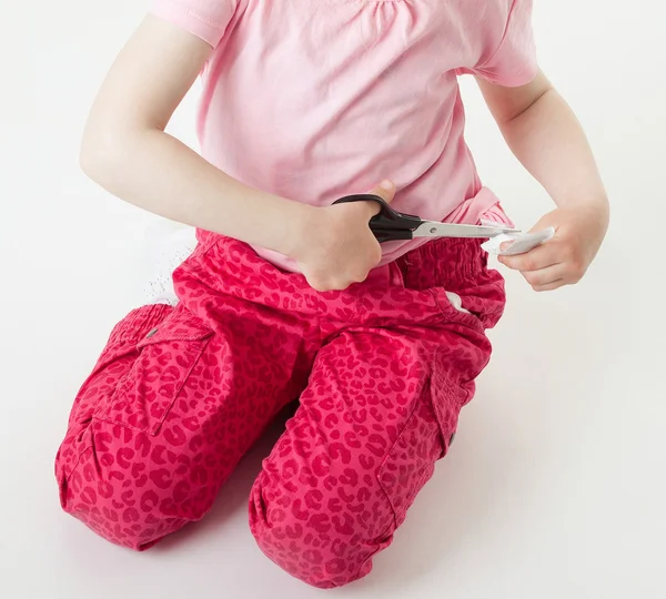 Little girl snipping off a brand label — Stock Photo, Image