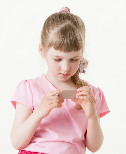 Flicka som läser texten på ett kort — Stockfoto