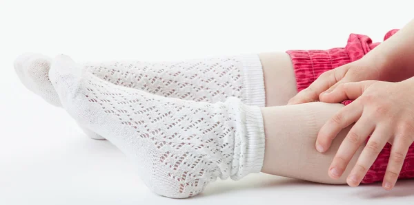 Little girl stroking her legs — Stock Photo, Image