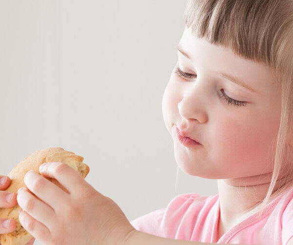 Pretty little girl eating a doughnut