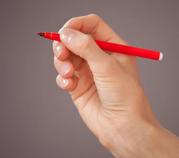 Mano femenina sosteniendo un rotulador rojo —  Fotos de Stock