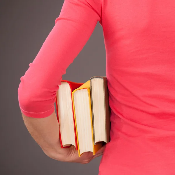 Onherkenbaar jonge vrouw met drie boeken — Stockfoto