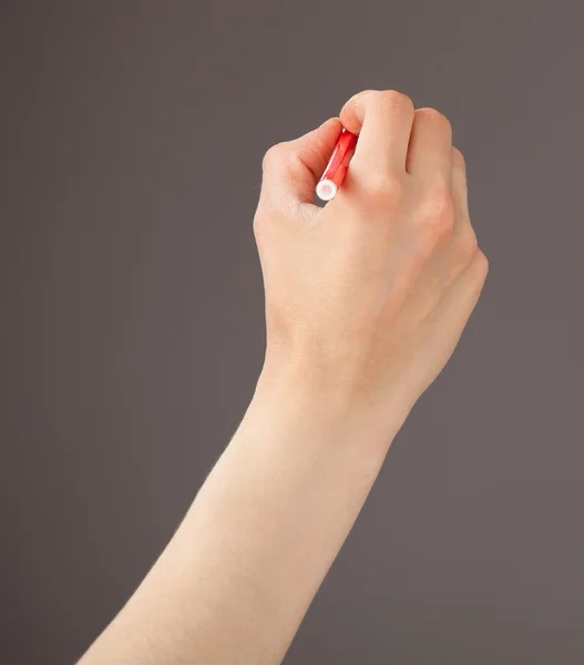 Female hand holding a red felt-tip pen — Stock Photo, Image