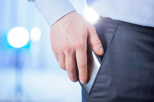 Businessman puts a smartphone in the pocket — Stock Photo, Image