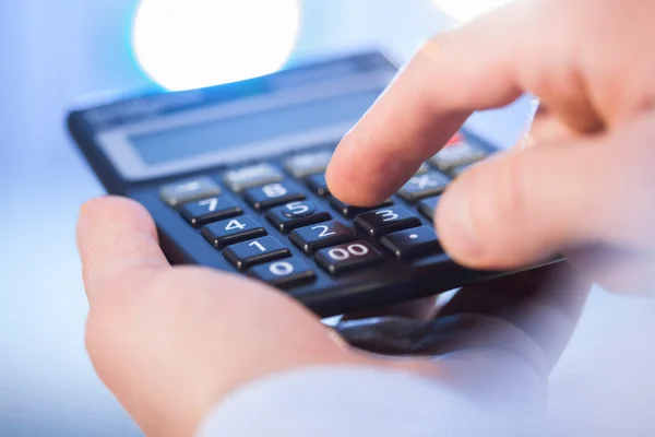 Businessman holding a calculator and counting — Stock Photo, Image