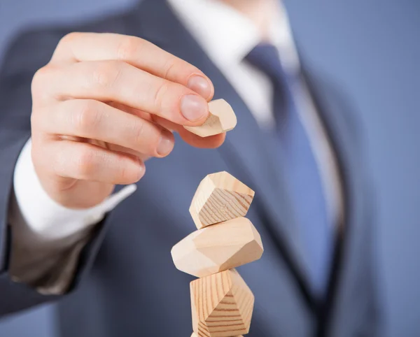 Geschäftsmann formt eine Holzpyramide — Stockfoto